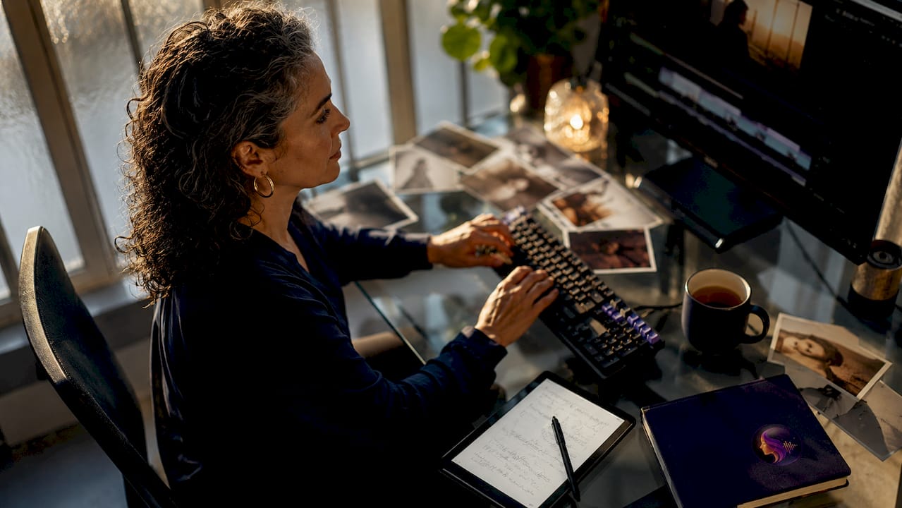 Woman editing tribute video at desk