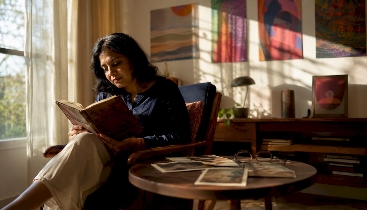 Woman reading an old diary in home library